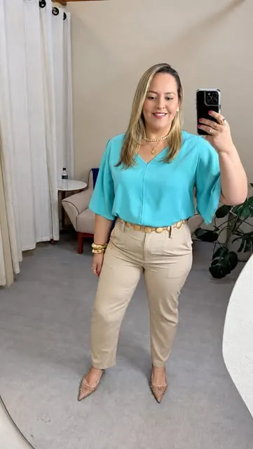 Mychelle no provador da Realce com blusa turquesa e calça bege